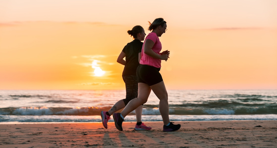 Two women jogging leisurely along the coast